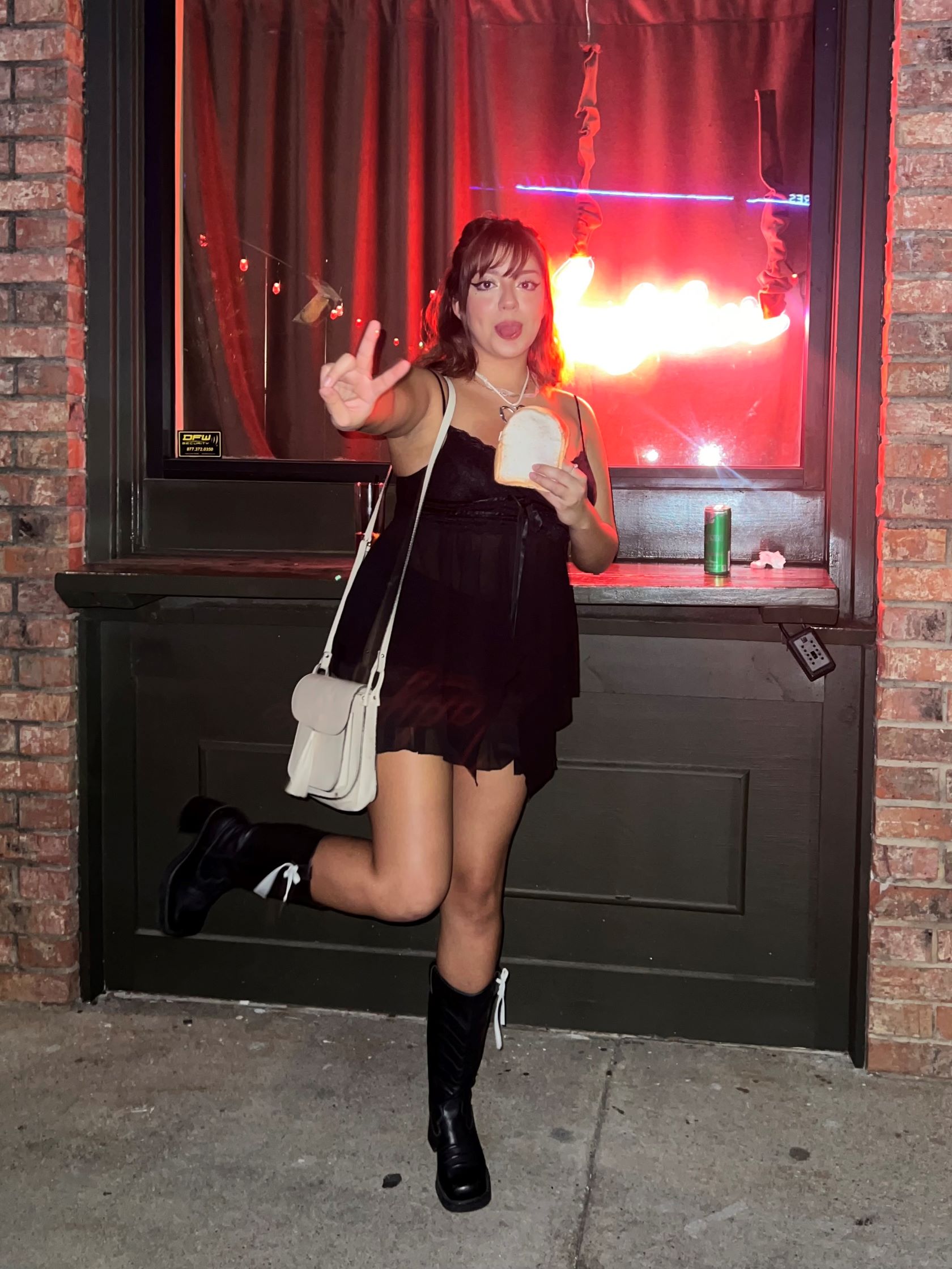 Daniella standing on one leg throwing a peace sign