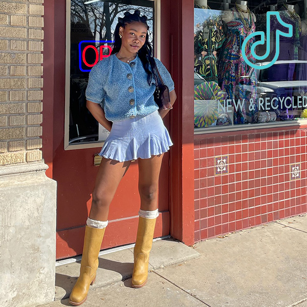 tt 1 person standing in front of buffalo exchange wearing short skirt and tall boots