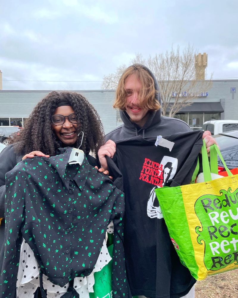 a couple shows off their $1 sale finds against a cloudy sky